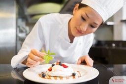 asian-chef-decorating-beautiful-dessert-in-kitchen